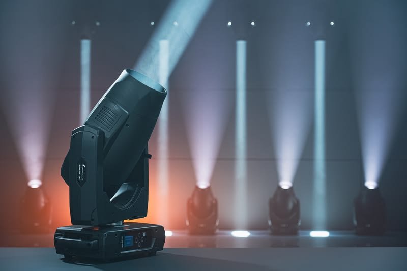 Stage lighting beams over a live event